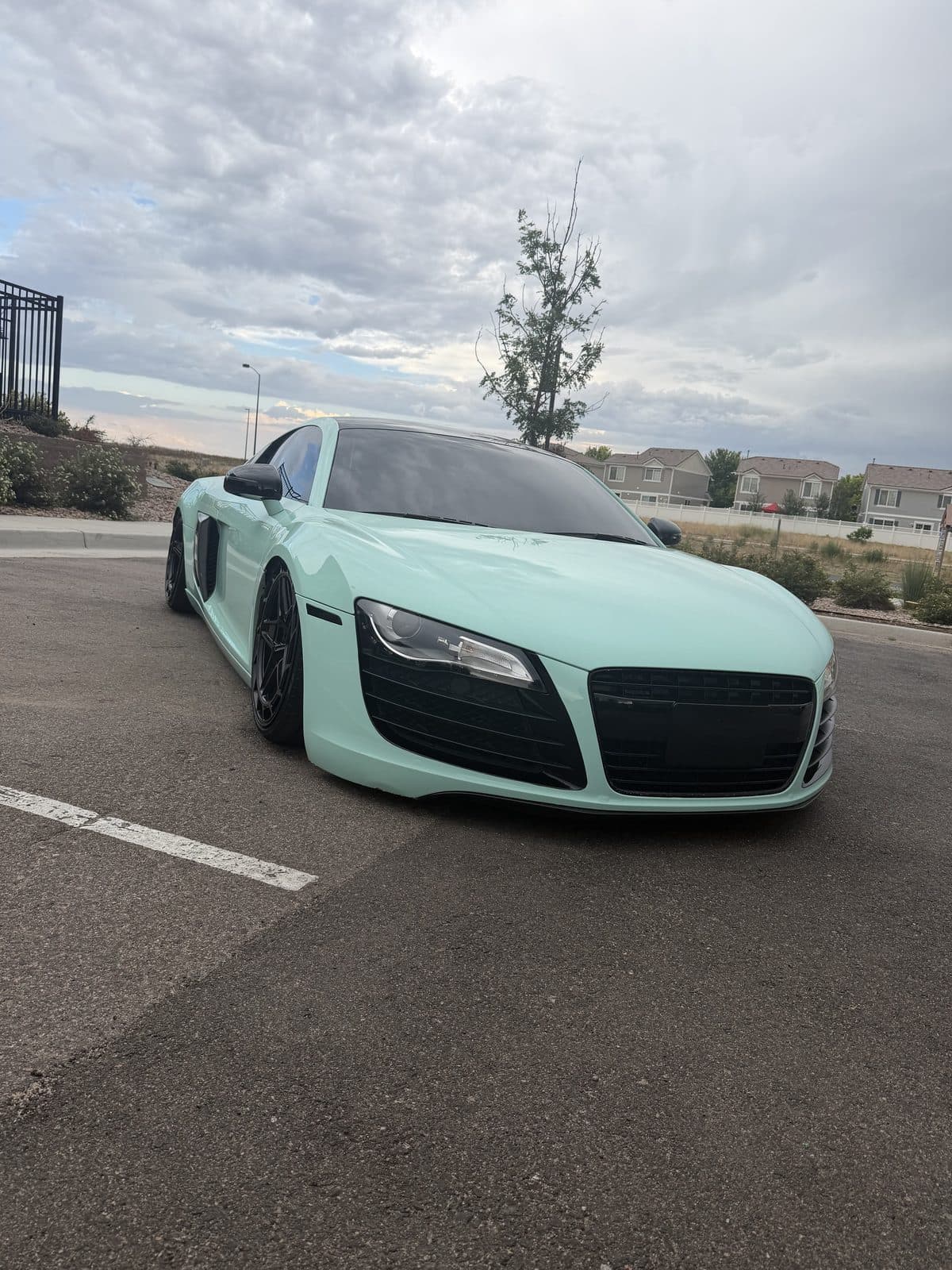 El Audi R8 verde menta, vista frontal, estacionado al atardecer.
